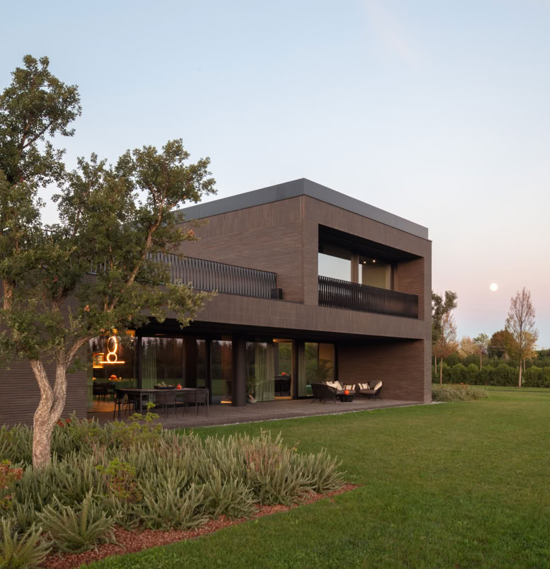 Un ampio portico protegge gli interni dall’irraggiamento solare e crea una piacevole continuità tra spazi interni ed esterni.