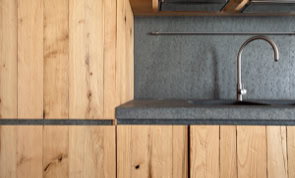 Interno con materiali naturali e arredi essenziali che richiamano la tradizione toscana.