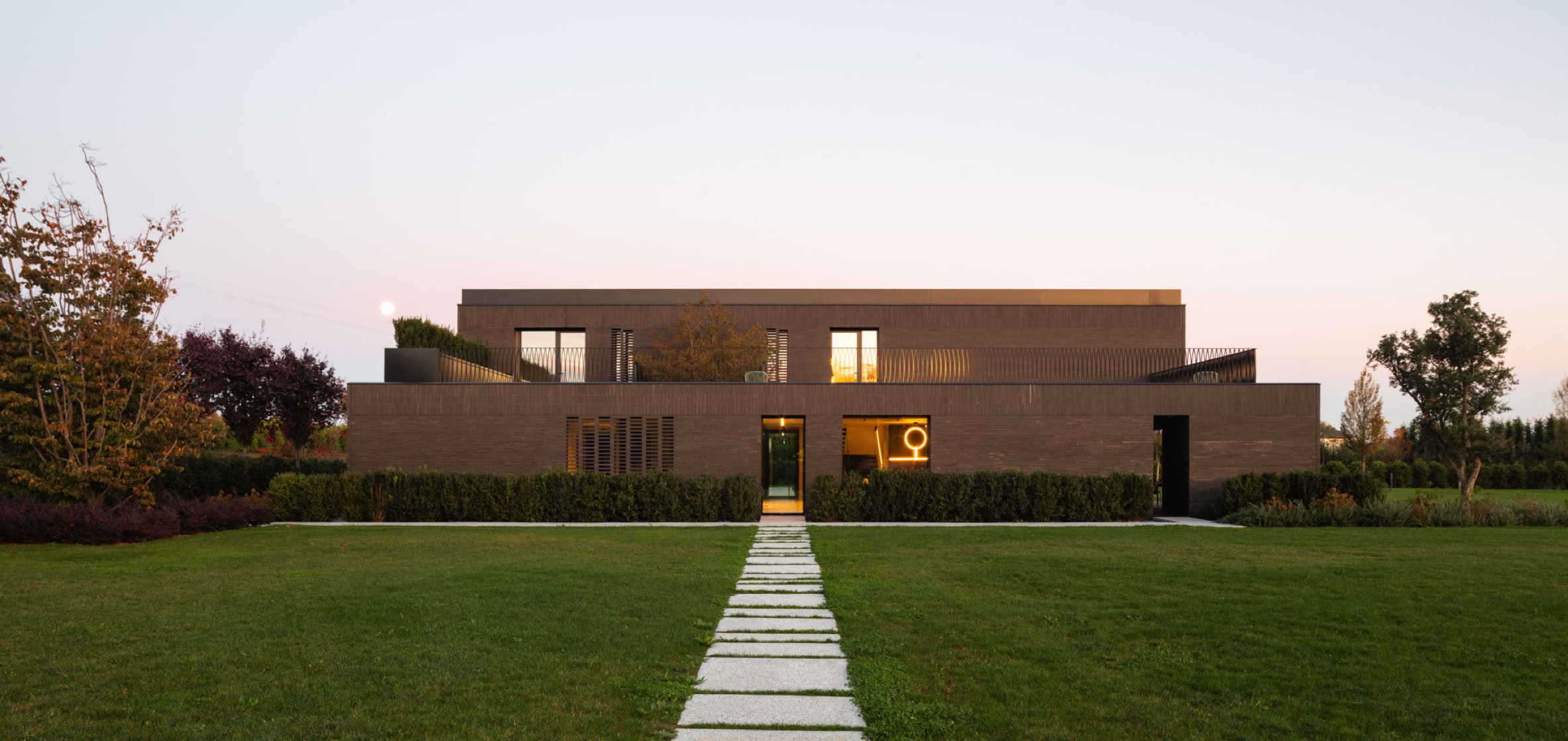 Contemporary brick villa by MIDE architetti featuring panoramic terrace, large windows, open-plan living, and refined interiors. A harmonious dialogue between architecture, light, and landscape.