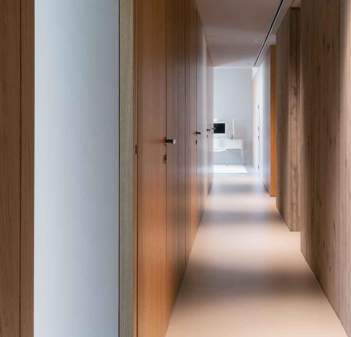 Interni contemporanei per la zona notte di questa villa progettata da MIDE architetti con armadiature a muro in legno.