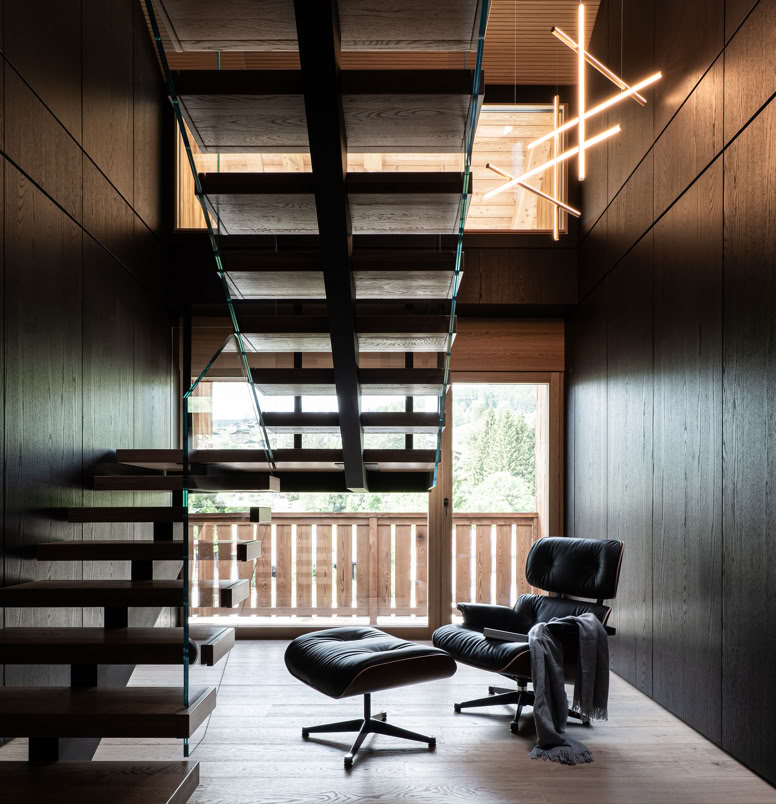 Designer internal staircase connecting sleeping area and living space in contemporary alpine penthouse.