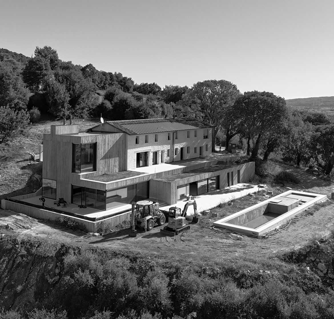 Farmhouse nestled on the hillside, harmoniously integrated into the surrounding context.
