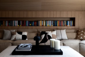 Spacious living room in luxury penthouse Cortina d’Ampezzo with designer sofa, armchairs, natural light, and wooden finishes.
