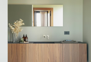 Premium finishes interacting with large glass openings overlooking the private garden.