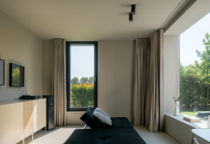 Spazio dedicato al relax, immerso nella quiete della corte interna. Le grandi aperture lasciano entrare la luce e il verde, creando un ambiente intimo e contemplativo, in continuità con il paesaggio vegetale.