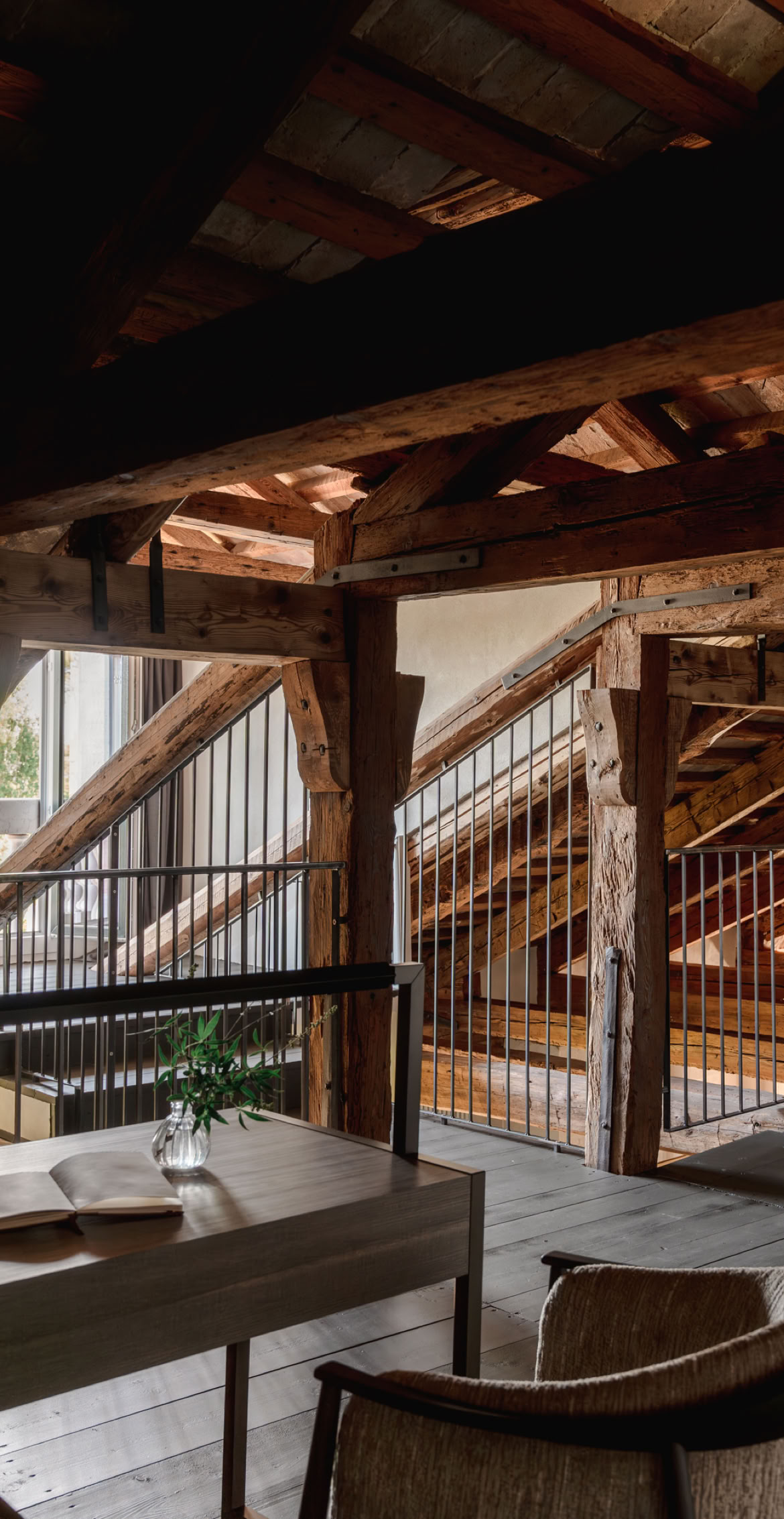 Area soppalcata in legno originale trattato e recuperato per ricavare uno studio contemporaneo.