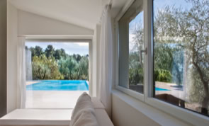 Vista interna della moderna pool house che guarda la piscina a sfioro.