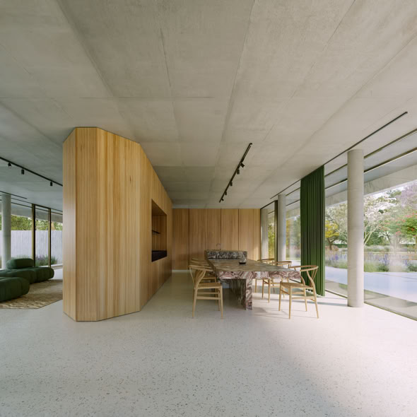 Dining room open to the garden, furnished with custom pieces and contemporary materials, creating a refined and welcoming atmosphere in continuity with the living area.