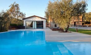 Piscina panoramica integrata nel giardino, pensata per godere del paesaggio naturale e della vegetazione mediterranea.