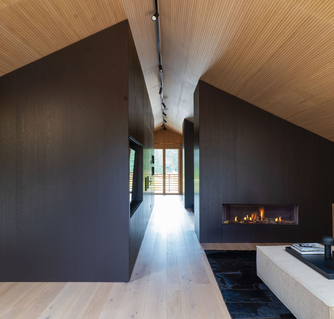 Spacious living room in luxury penthouse Cortina d’Ampezzo with designer sofa, armchairs, natural light, and wooden finishes.
