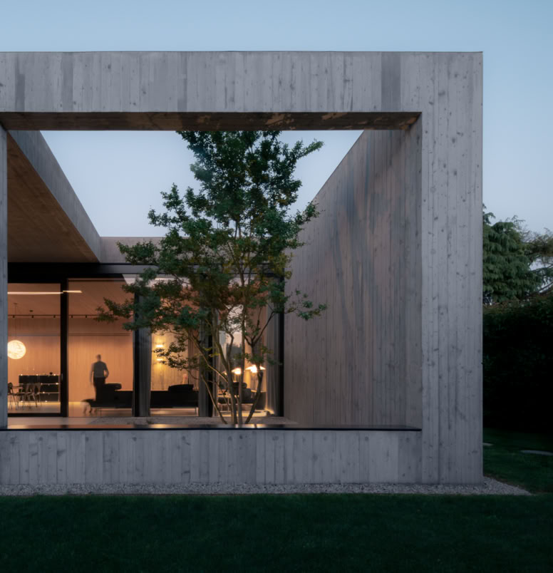 Contemporary single-family house designed by MIDE architetti, blending exposed concrete and natural wood. Open-plan living, central patio, and seamless connection with nature and garden.