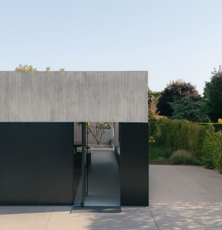 Main entrance of the villa with a large portal opening onto the inner courtyard enriched with vegetation.