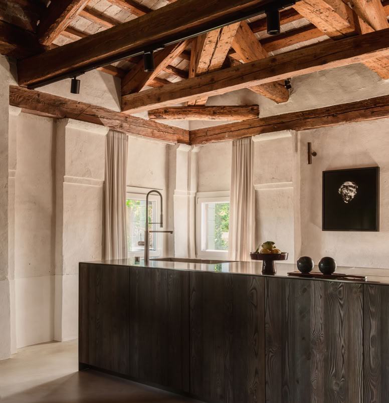 La cucina, integrata nell’open space, unisce praticità e stile contemporaneo, dialogando con la luce naturale e il panorama sul fiume.