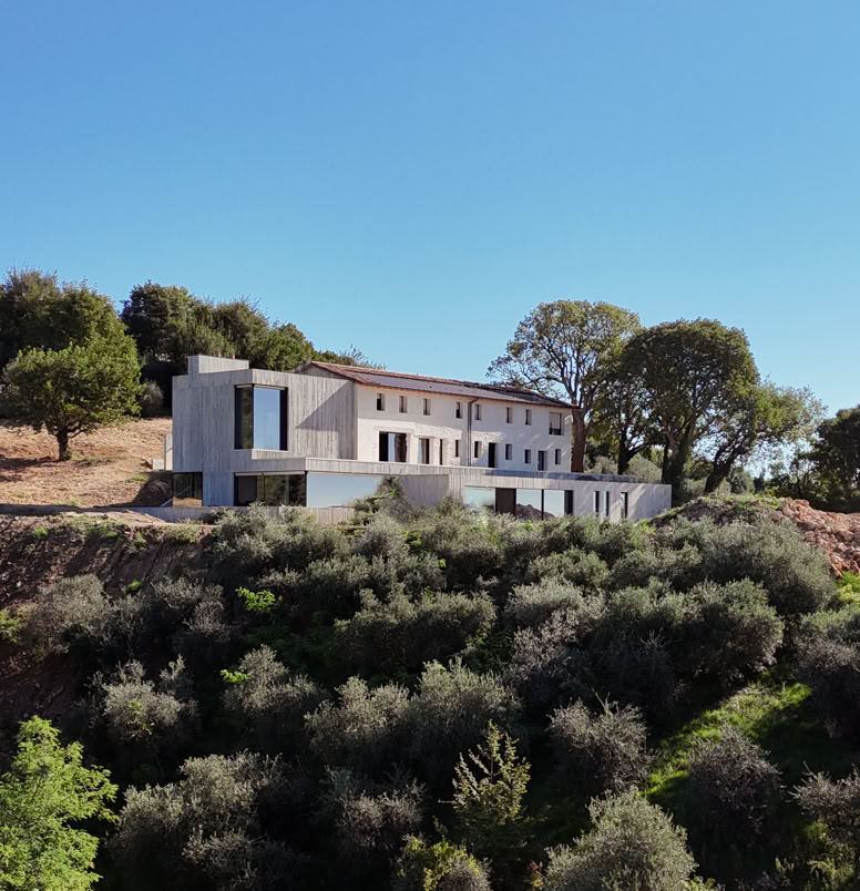Renovated historic farmhouse in Treviso hills with contemporary expansion, panoramic views, double-height interiors, flat roof, and integrated swimming pool.