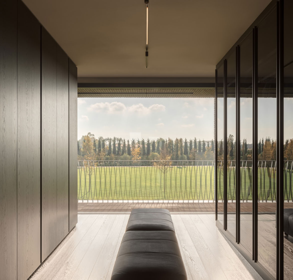 Walk-in wardrobe overlooking the park, connected to the master bedroom of the brick villa designed by MIDE architetti.