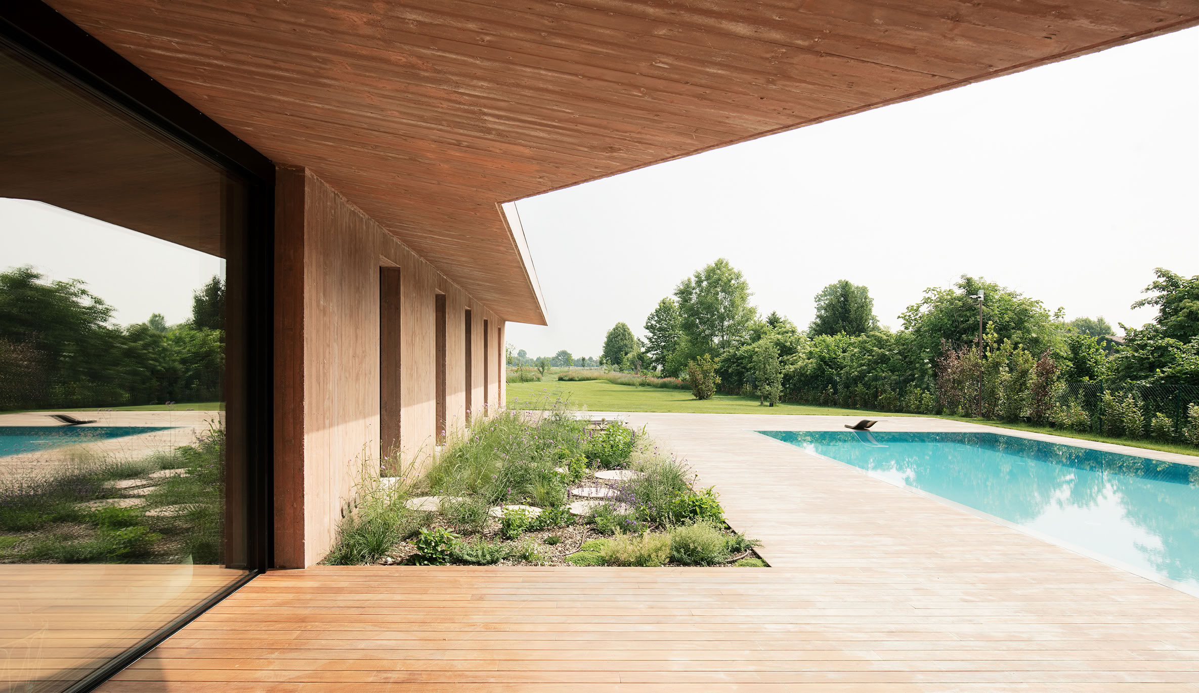 View from porch of solarium and infinity pool designed by MIDE architetti for modern residential living.