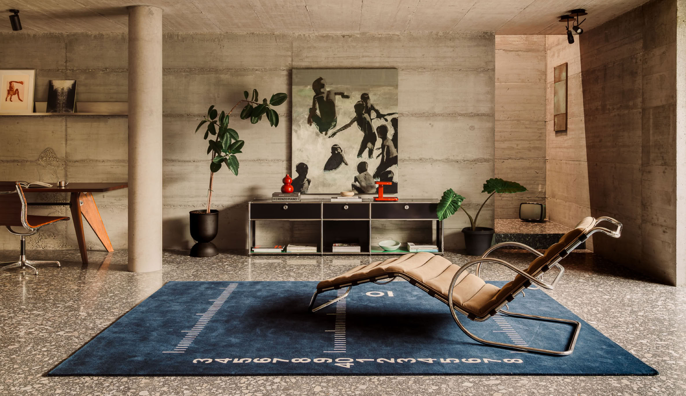 Una casa brutalista con materiali contemporanei sviluppata da MIDE architetti. In foto l'area relax al piano terra con pezzi di arredo di design.